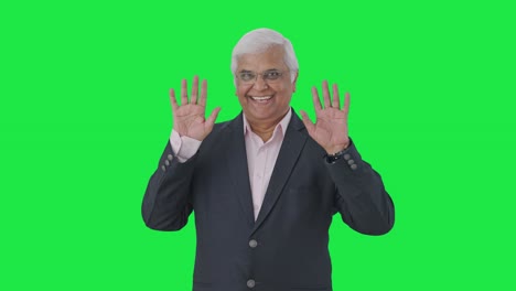 Happy-Indian-senior-manager-saying-Hello-Green-screen