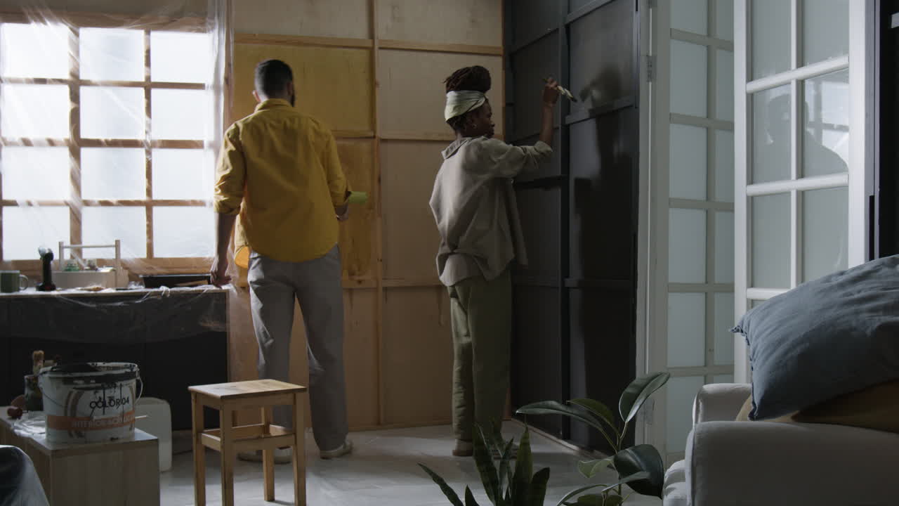 People painting a room as part of a DIY home improvement project