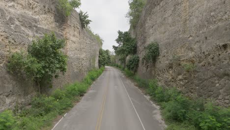 Drone-flying-between-old-road-connecting-La-Romana-to-Higuey,-Dominican-Republic