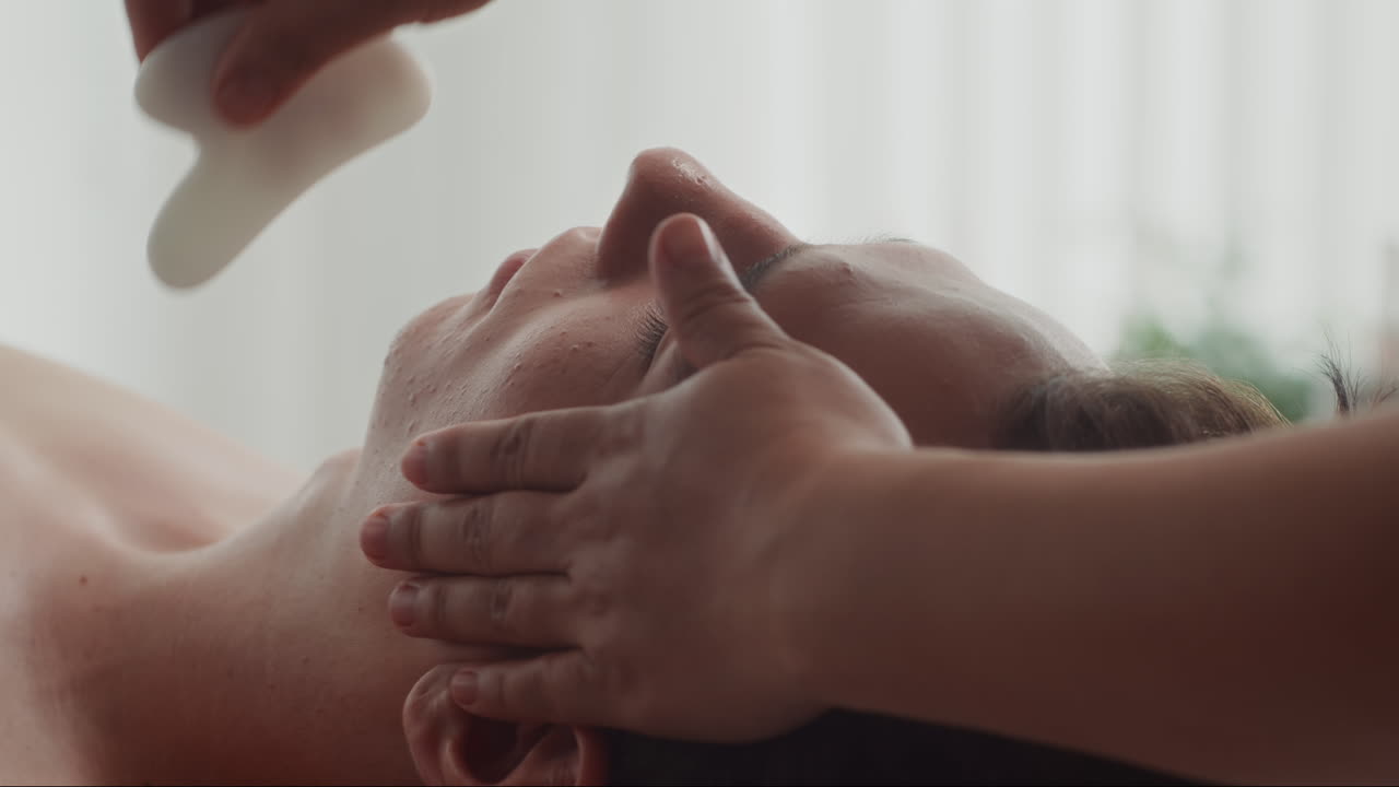 Masseur Using Gua Sha Tool Doing Beauty Procedure to Man