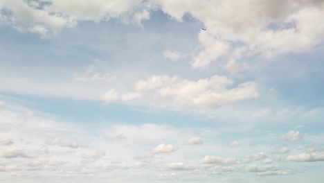 toma amplia extrema de un avión que vuela a través de un cielo diurno con nubes esponjosas