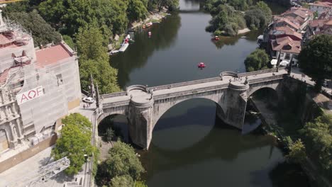 Histórico-Puente-De-Piedra-Sobre-El-Río-Con-Vistas-Al-Paisaje-Urbano-De-La-Ciudad-De-Amarante,-Vista-De-La-órbita-Aérea