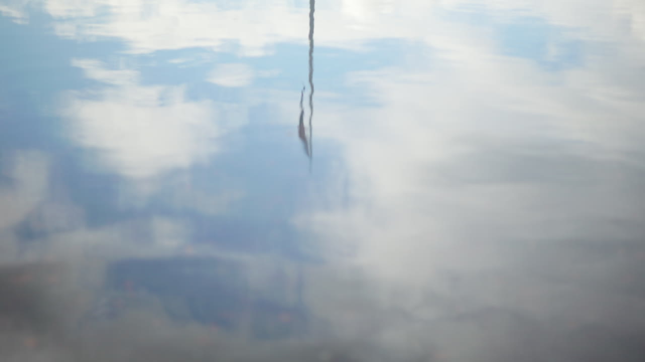 Norwegian flag waving in the breeze, reflected in the water