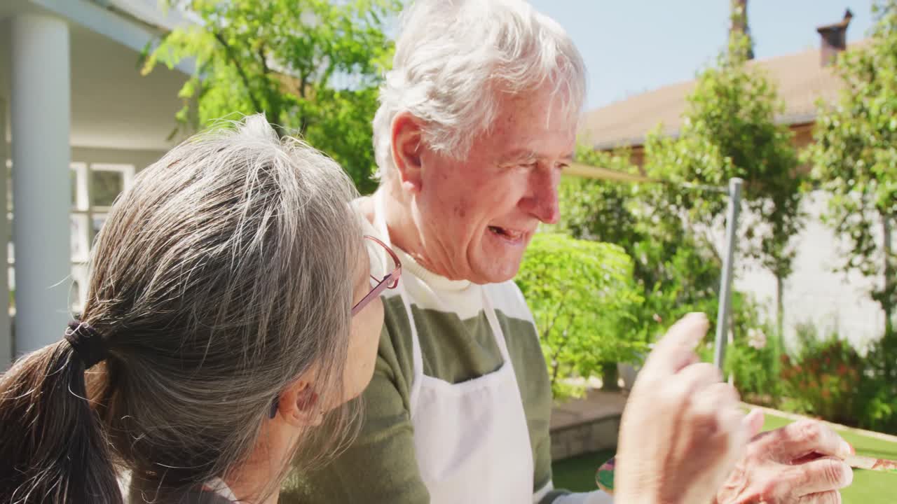 ⁇ 은 날에 정원에서 그림을 그리는 행복한 다채로운 고위 부부