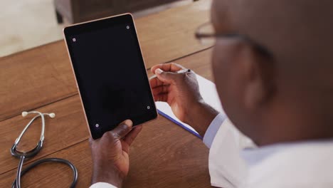 Médico-Afroamericano-Haciendo-Consulta-De-Videollamada-Usando-Tableta-Digital-Con-Espacio-De-Copia