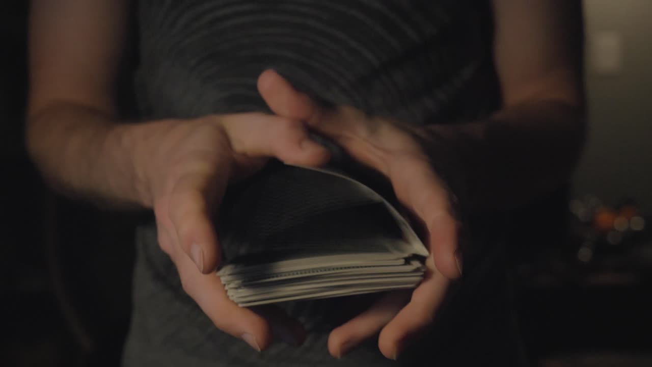 A slow motion push-in of a deck of cards being shuffled in slow motion
