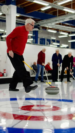 seniors playing curling on ice rink