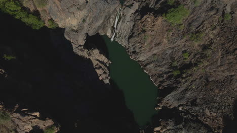 4k bird’s eye view drone footage overflying the canyon in namibia’s namib region, revealing a tranquil lake below. the stunning contrast between the canyon’s rugged cliffs and the serene lake