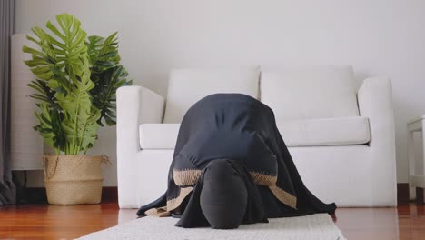 asian young woman muslim prayers bow to pray for blessings in the living room, belief in islam muslims pray at home daily as a blessing for themselves and their family