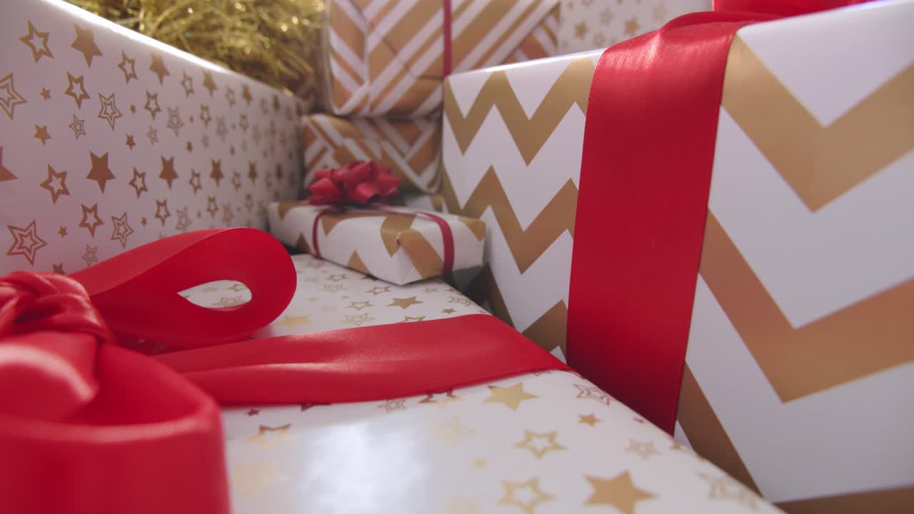 uma bela pilha de presentes embrulhados de forma clássica com laços vermelhos brilhantes