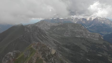 drone gliding through clouds over the monzoni ridge, catinaccio dolomites visible in the background