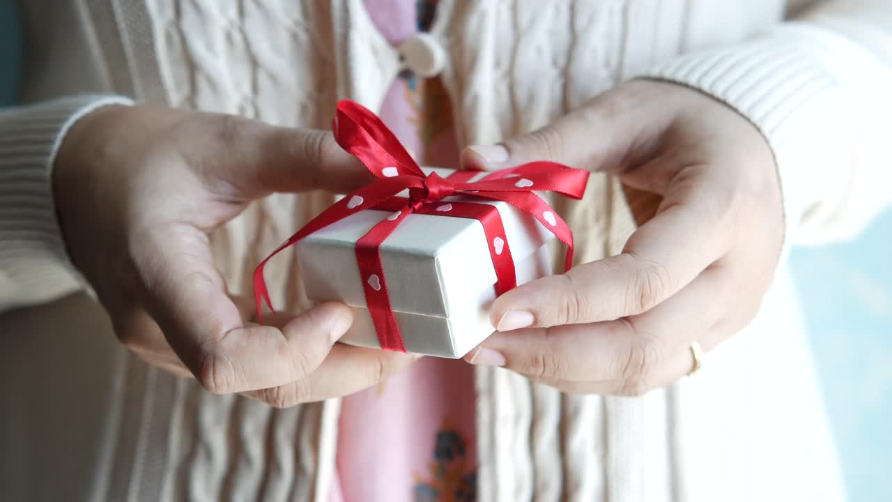 작은 선물 상자를 들고 있는 여자