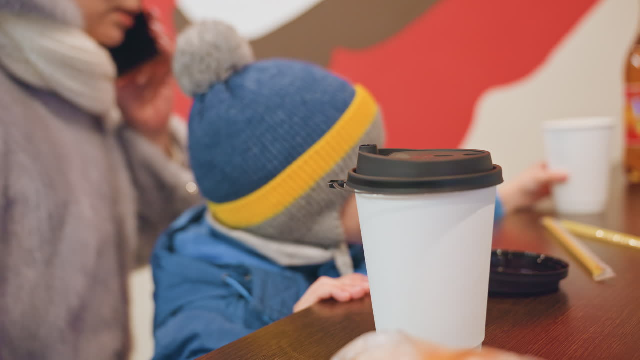 Istante caldo in un caffè di famiglia. Madre e figlio si godono una visita accogliente al caffè. Scena familiare casuale con caffè e calore all'interno. Ritratto spontaneo di madre e figlio che si rilassano in un accogliente ambiente da caffè.