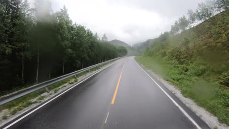 view from the car in the rain driving on wet roads. driving a car on a road in norway