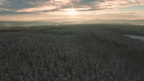 Espectacular-Y-épica-Toma-De-Drones-De-Los-Bosques-Y-Campos-Con-Montañas-En-El-Fondo,-Vista-De-Pájaro,-Durante-Una-Puesta-De-Sol-O-Un-Amanecer-Al-Atardecer-O-Al-Amanecer