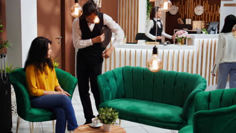 asian woman paying for coffee and giving tip to waiter