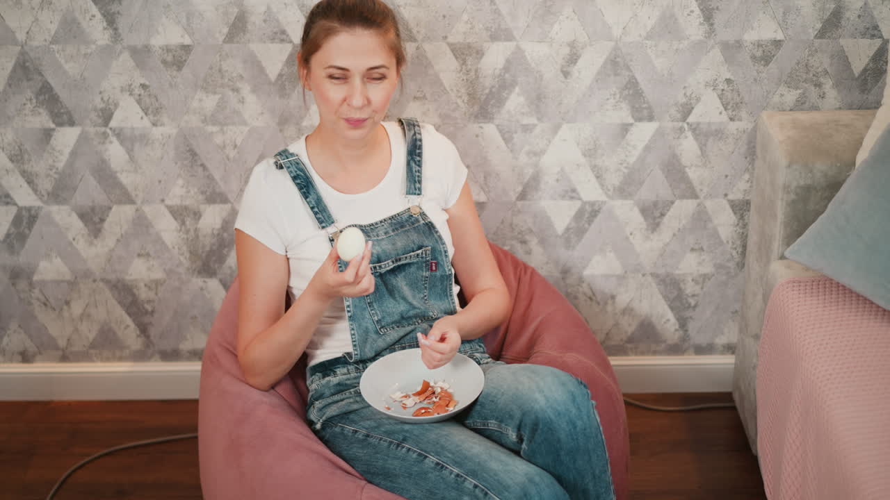 Woman Peeling and Eating an Egg