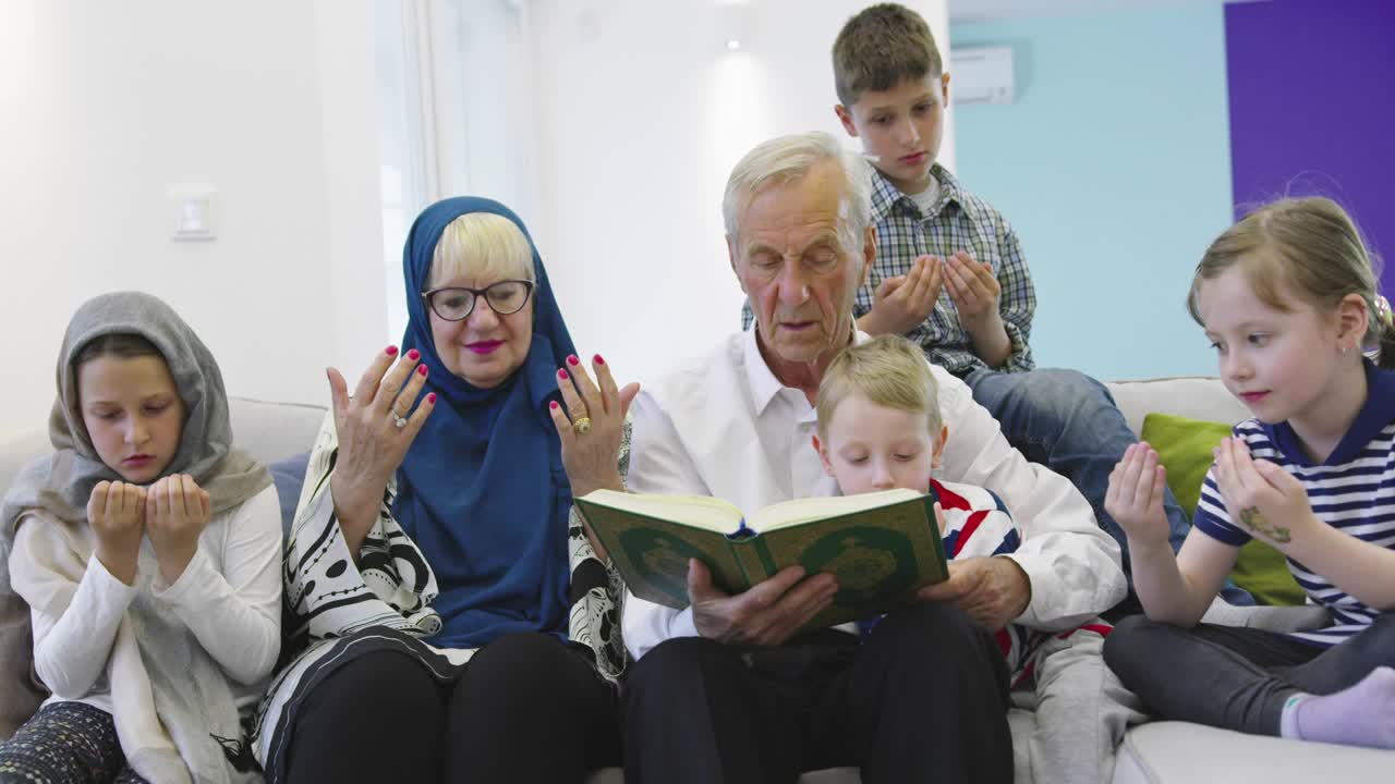 Keluarga Muslim lintas generasi, kakek-nenek membaca Al-Qur'an bersama cucu di rumah.