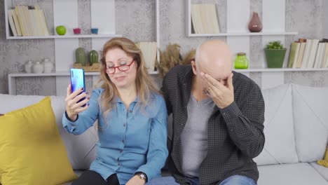 mature senior couple having emotional video chat on smartphone.