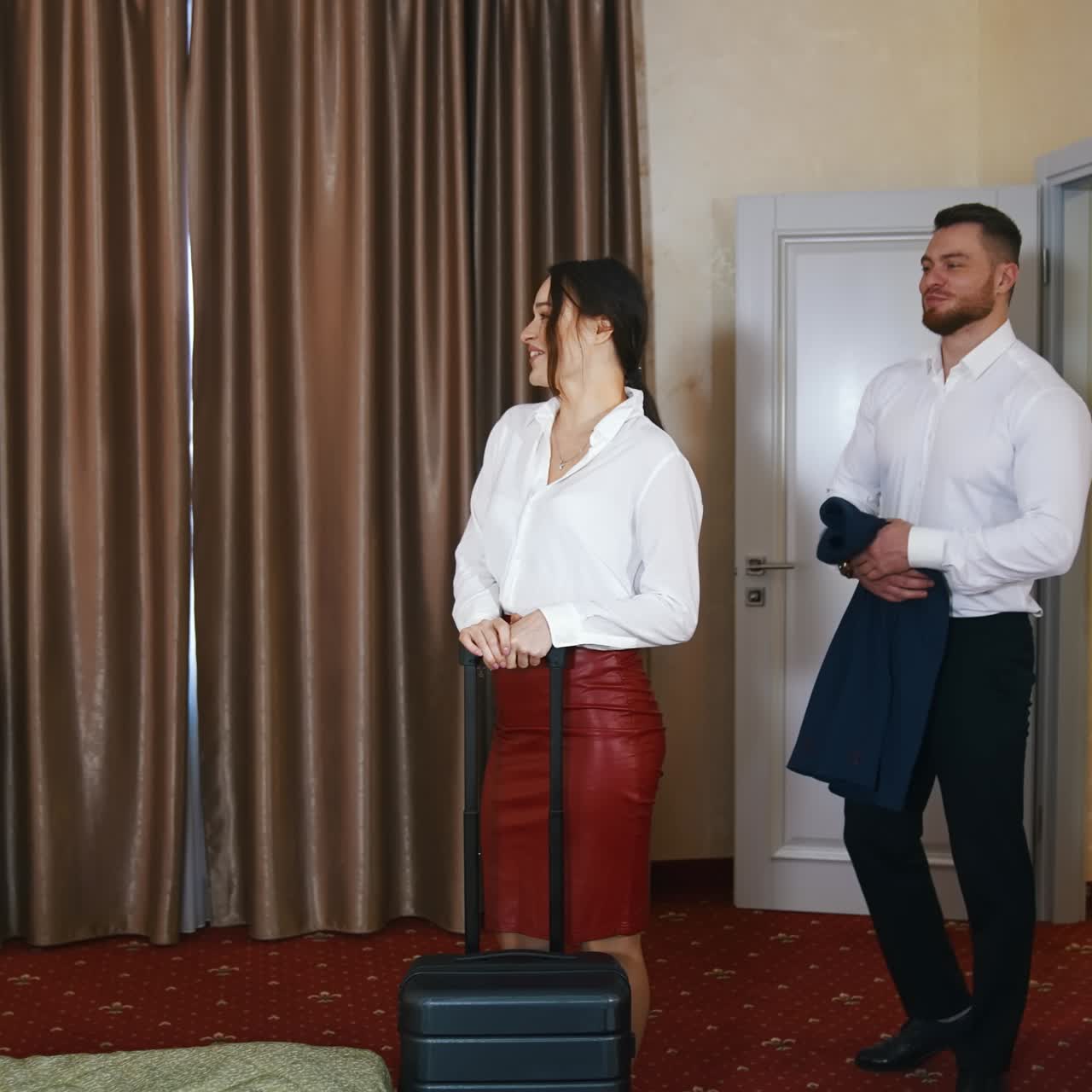 Young couple entering the hotel room with suitcases. Happy family with luggage during vacation. Cheerful married couple arriving at hotel