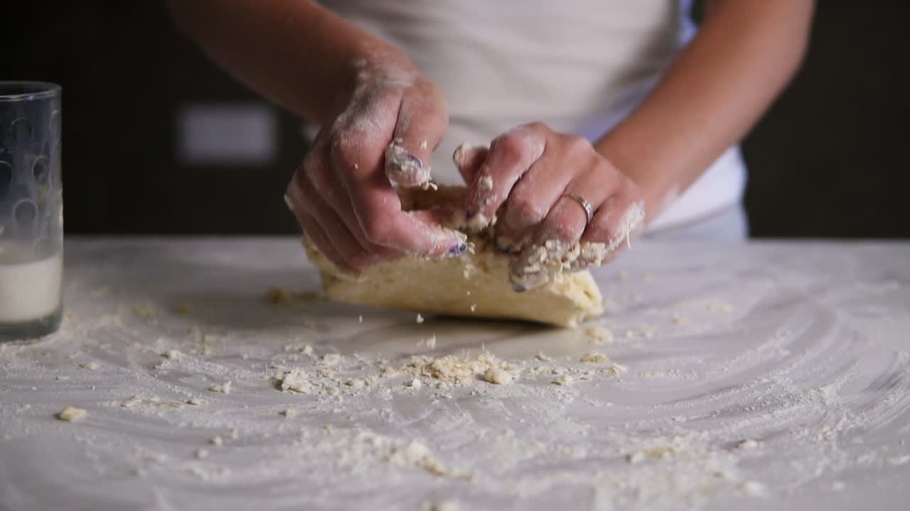 mujer amasando la masa en harina en la mesa. el panadero prepara la masa. las manos amasando la masa. toma en cámara lenta