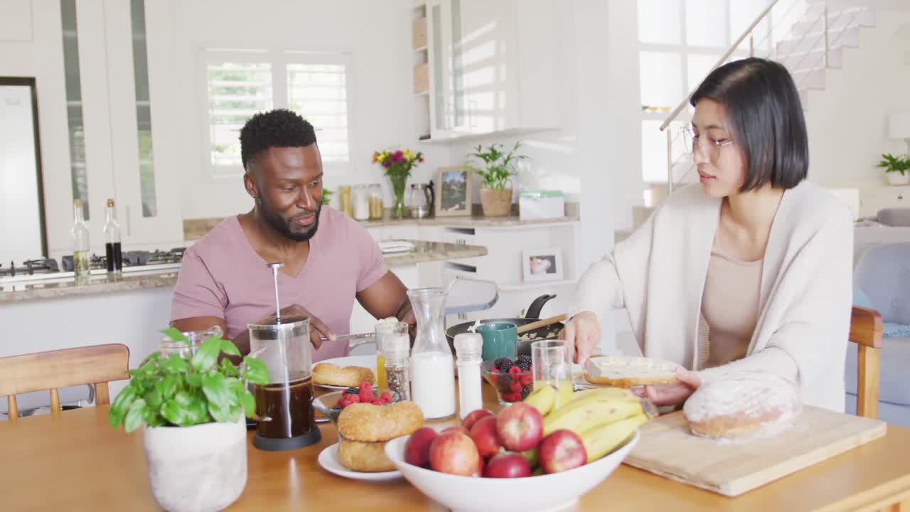 테이블 에 앉아 아침 식사를 하는 다양한 행복 한 부부