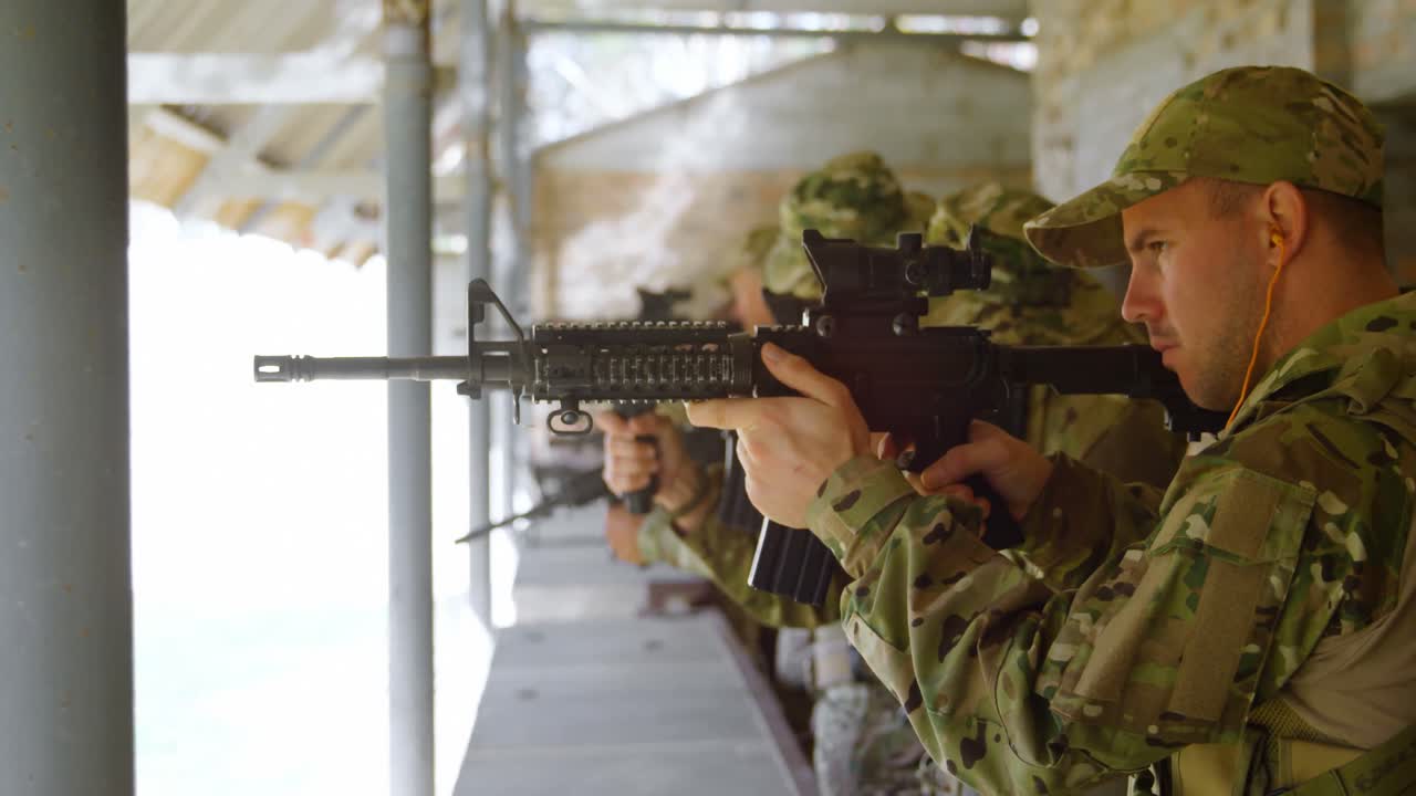 vista lateral de soldados militares de raza mixta disparando rifle en práctica de tiro durante el entrenamiento 4k