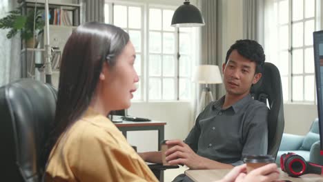 asian female ux architect happy talking with male design engineer, they work on mobile application in office