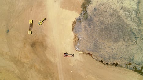 drone top down perspective of heavy machinery loaders, pusher, excavator