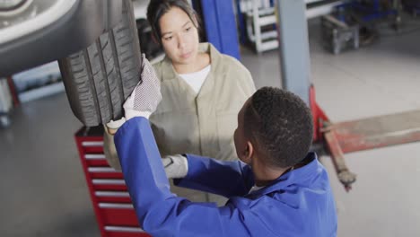 video of two diverse female car mechanic changing tyre