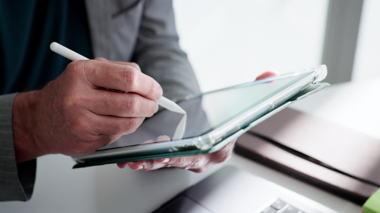Close-Up of Hands Using a Digital Tablet with a Stylus