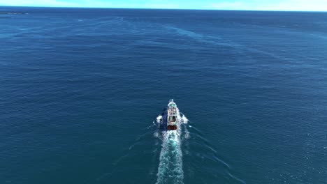 barco pesquero navegando a través del océano en la isla de skrudur, faskrudsfjordur, islandia oriental - toma aérea de drones