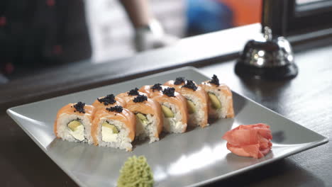 professional chef in a commercial kitchen in a restaurant or hotel is serving sushi rolls