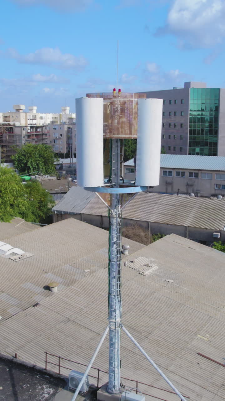 Cell phone mini tower base station on a building in a small industrial area for mobile devices - antenna emitting non-ionizing radiation - Vertical video