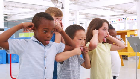 niños de escuela haciendo caras en un centro de ciencias