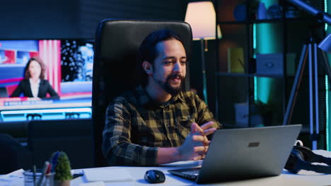 hombre sonriente relajándose en la sala de estar viendo clips divertidos de internet en la computadora portátil