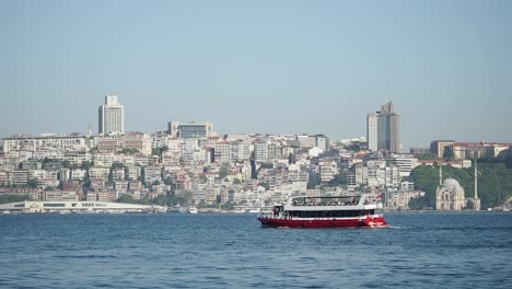ferry boat cruising on the water with a city skyline and mosque in the background