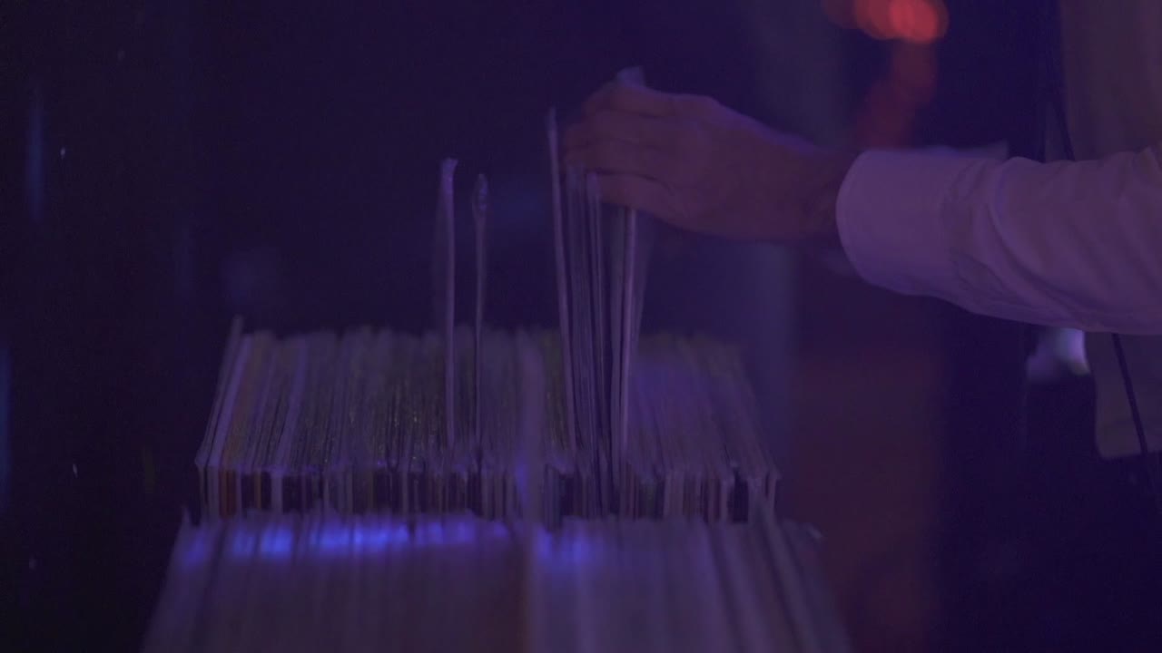 dj eligiendo un vinilo de la colección en la fiesta, de cerca