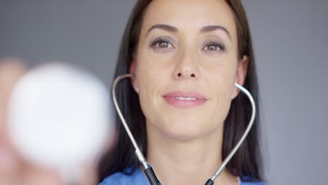 Attractive-young-nurse-using-a-stethoscope