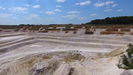 sloping stairs created on the ground after the process of mining kaolin. drone footage. blue sky background.