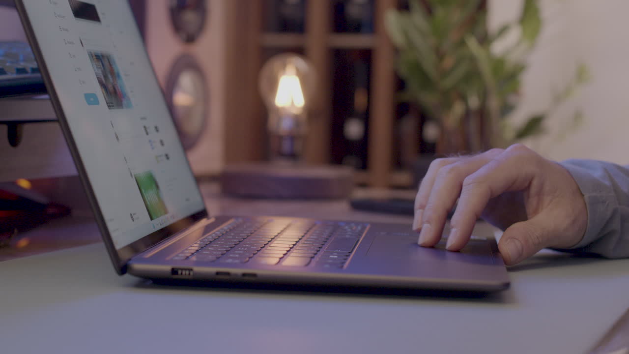 primer plano de las manos de un hombre navegando por la web en su computadora portátil.