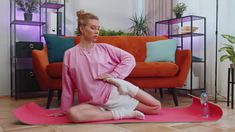 young woman doing yoga stretching excersices on mat, workout, burning fat calories, training at home