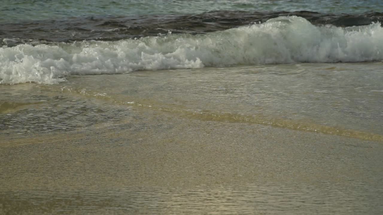 모래사장에서 부서지는 파도의 느린 동작, 낮은 각도