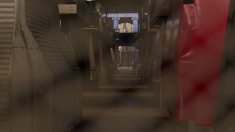 blurred view of an alley, seen through a red fence