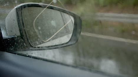 driving on rainy day and looking through mirror, interior car view