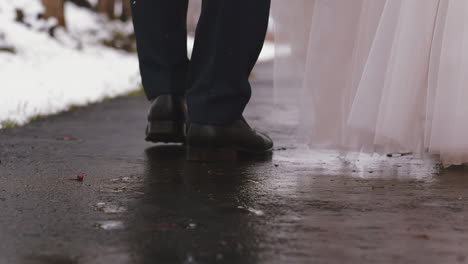 man-and-woman-in-festive-clothes-walk-along-empty-wet-road