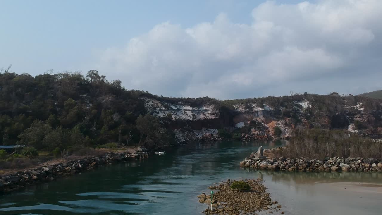 울퉁불퉁한 사암 절벽으로 둘러싸인 큰 어귀로 이어지는 바다 입구의 항공 비디오