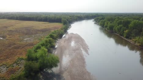 Vista-Aérea-De-Drones-Siguiendo-El-Sendero-De-Agua-Del-Río-Iowa-Y-Un-Gran-Banco-De-Arena-En-El-Río