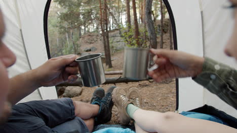 couple relaxing inside tent in forest