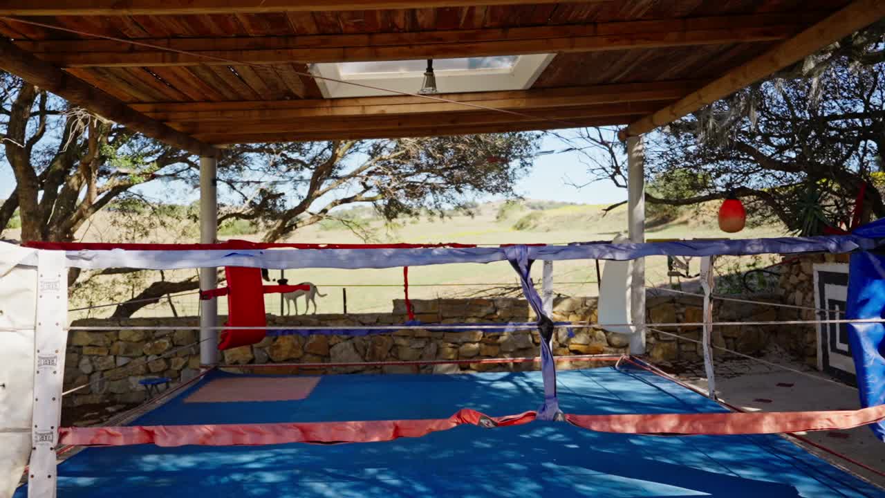 área de boxeo y artes marciales vacía en el gimnasio de la calle con sacos de boxeo